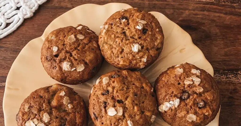 Muffin funcional de cenoura e aveia com aveia em flocos sobre prato rústico