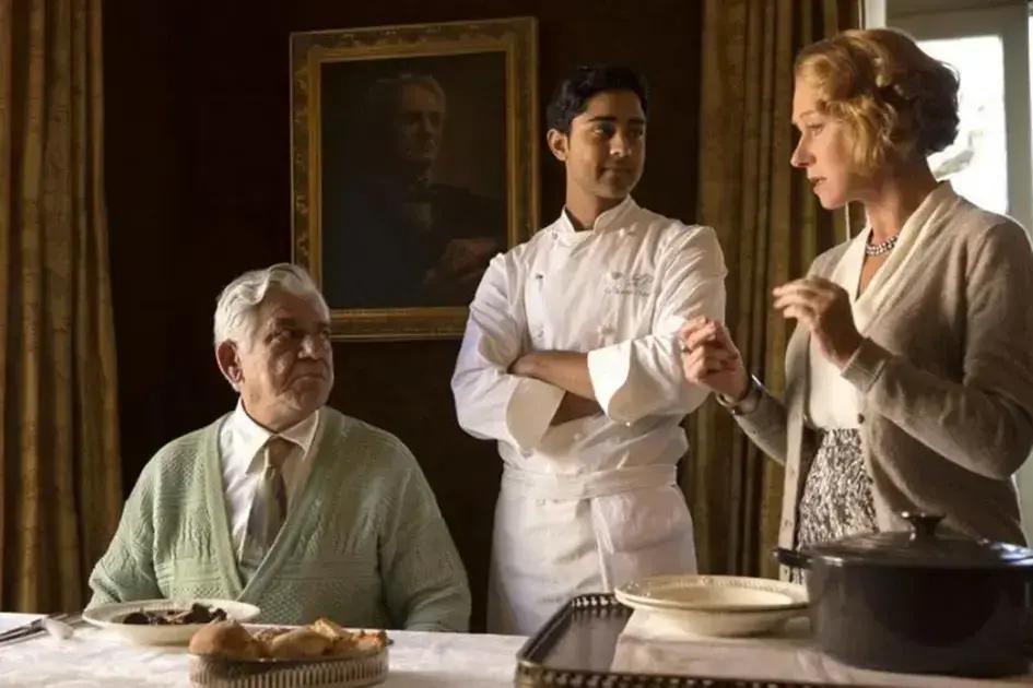 A 100 Passos de Um Sonho: um filme sobre cultura, comida e união | Benverde Cena do filme A 100 Passos de Um Sonho com três personagens em uma sala de jantar, representando o diálogo entre tradição, juventude e cultura através da comida.